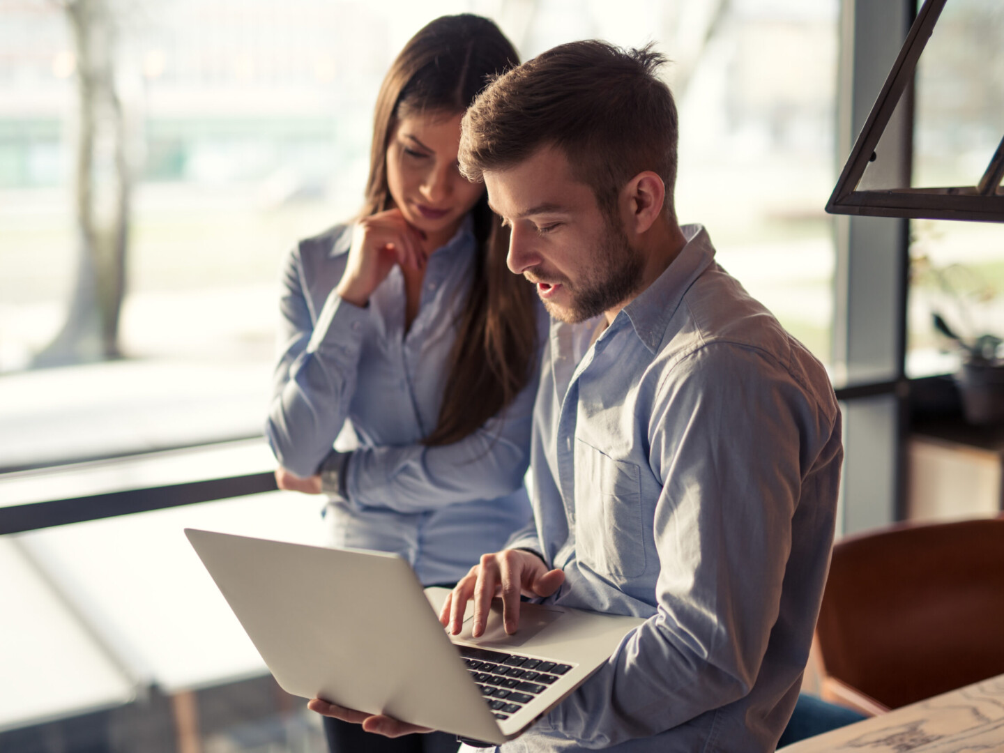 I Need a Health and Safety Plan – Where do I Start? Hero image is of a caucasian man and woman talking whilst the man holds a laptop. They are both in office wear.